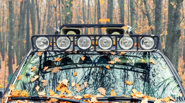 An SUV with a custom made roof rack with six light units and dual audio megaphones in the back