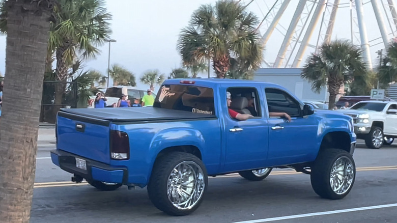 A blue pickup truck with the now-illegal Carolina squat modification