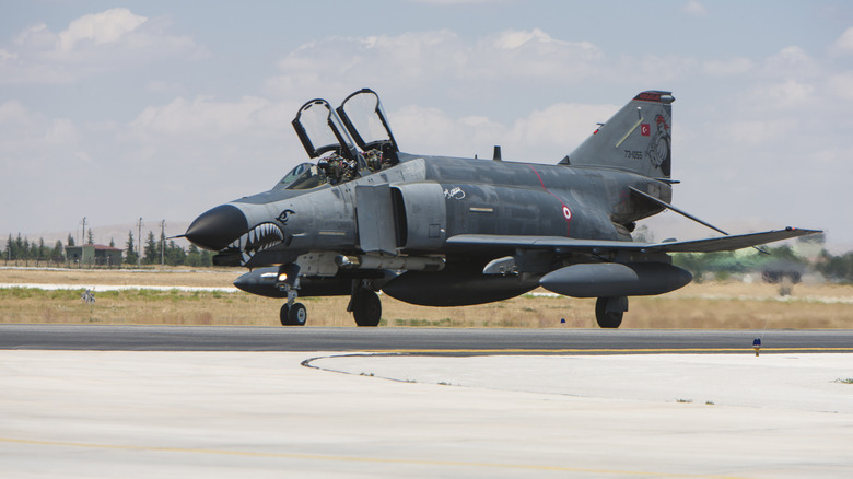 an F-4 with open hatch on runway