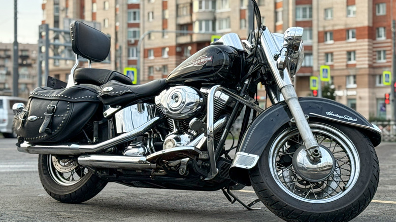 A chrome and black Harley-Davidson Softail Heritage Classic bike parked on the street, right-view visible.