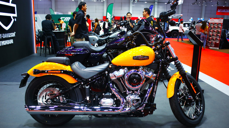 A black and yellow Harley-Davidson Street Bob bike on display indoors at an exhibition.