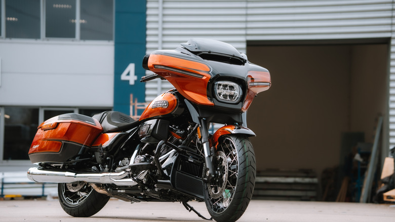 An orange and black classic Harley-Davidson CVO Street Glide parked on its kickstand.