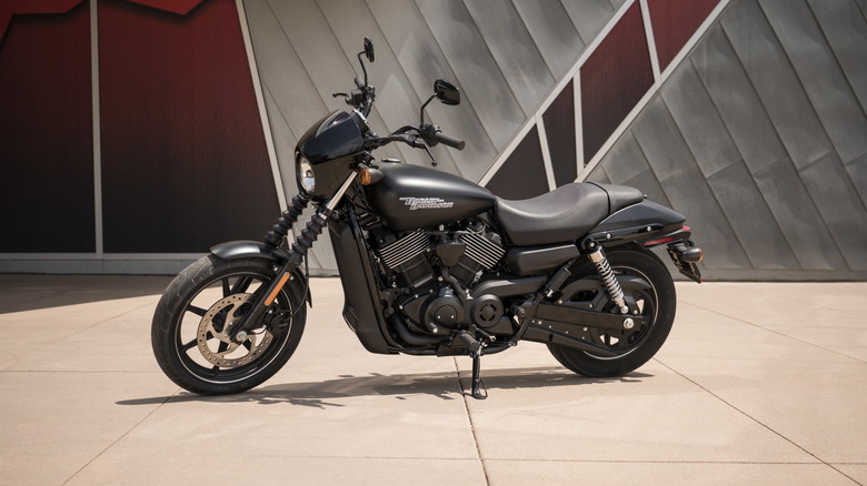 A black Harley Davidson Street 750 from the 2019 model year parked in front of a modern wall