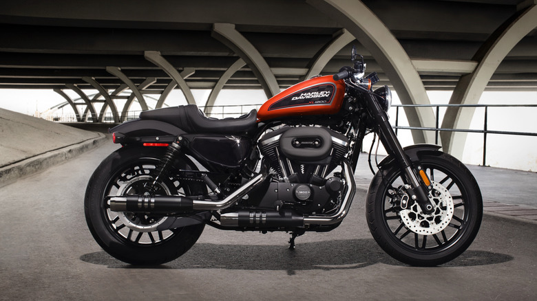 A red and black Harley Davidson Roadster parked underneath a bridge
