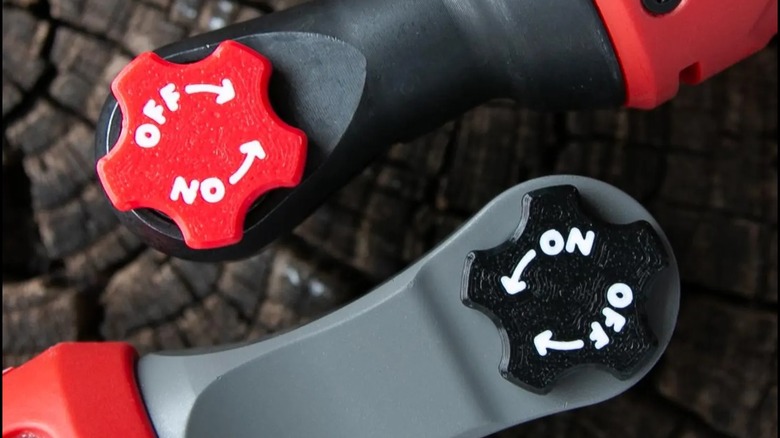 A close-up of two Milwaukee M12 ratchets with 3D-printed magnetic switch knobs.