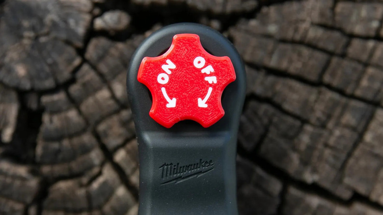 A Milwaukee M12 ratchet fitted with a red magnetic switch cap labeled ON and OFF.