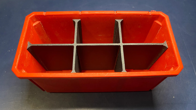 A close-up of a red Milwaukee Packout bin with custom 3D-printed PLA dividers.