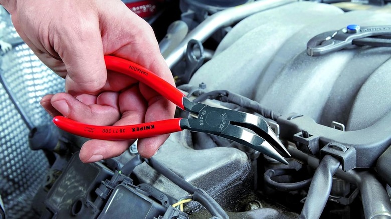 mechanic using Knipex angled nose pliers