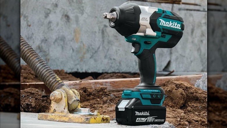 An impact wrench placed outdoors on the ground.
