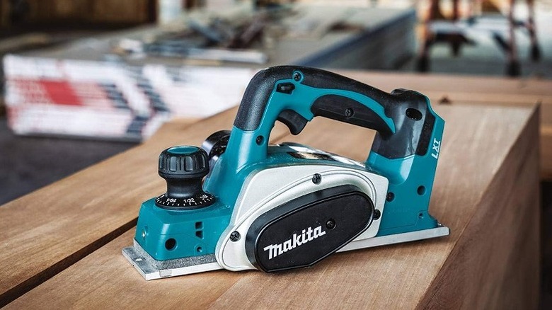 A belt sander placed on a wooden table.