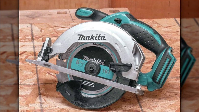 A cutting saw placed on tiles.