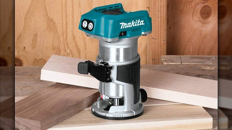 A compact router placed on piles of wood.
