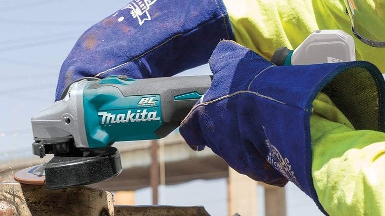 Worker using an angle grinder on wood.
