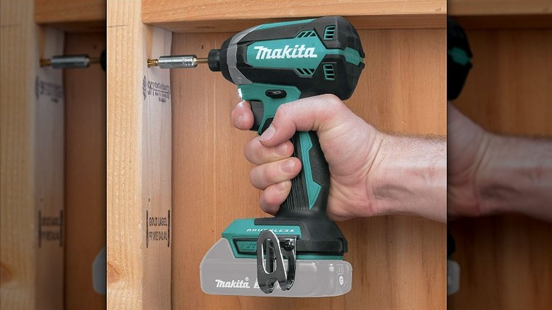 Using impact driver to drive a fastener into wood.