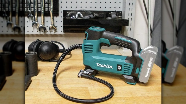 A Makita inflator placed on work table along with other tools.