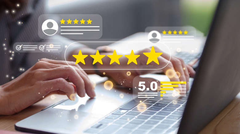 Holographic image of five star ratings and five star boxes above a laptop.