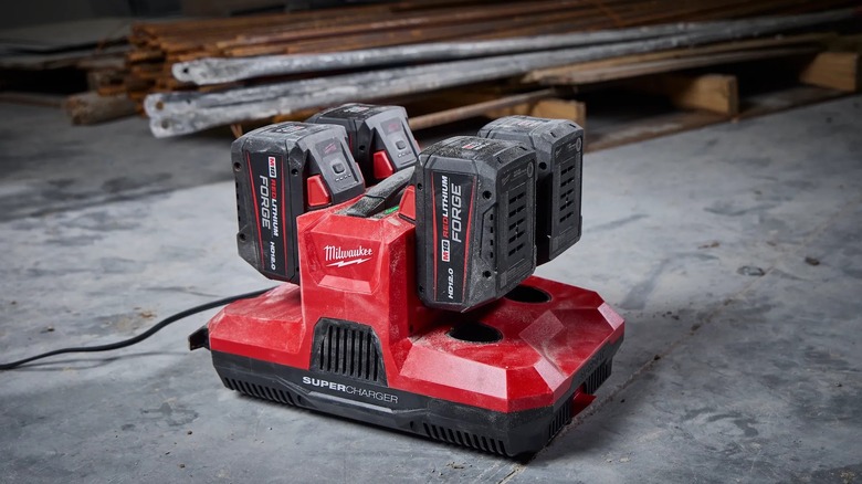 four bay charger powering up four large batteries on jobsite