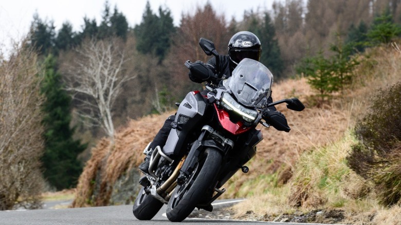 A rider leaning a 2024 Triumph Tiger 1200 GT Explorer into a curve.