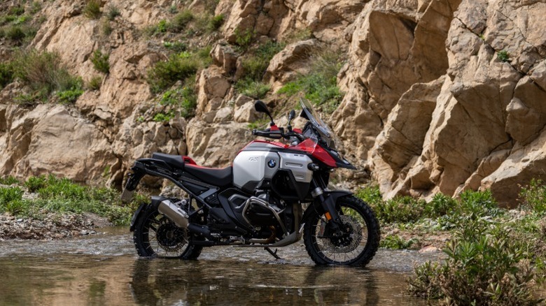 A BMW R 1300 GS Adventure parked in a shallow stream.
