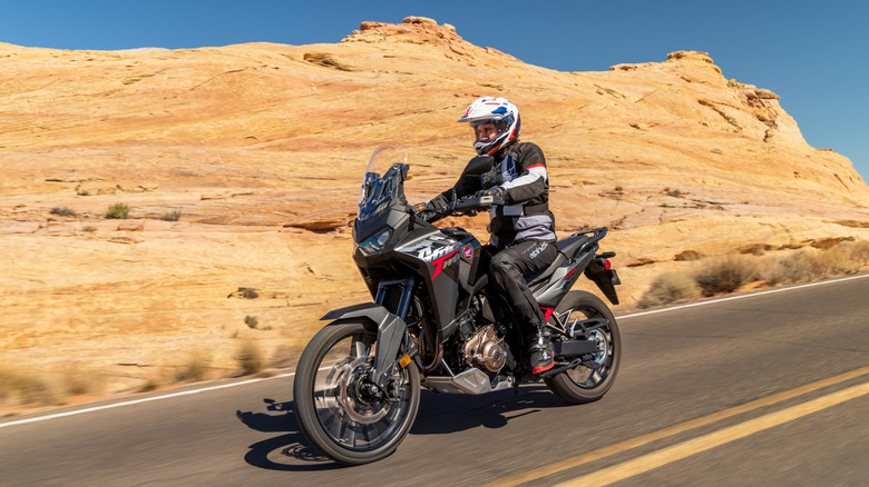 A rider on a Honda Africa Twin cruising through desert canyons.
