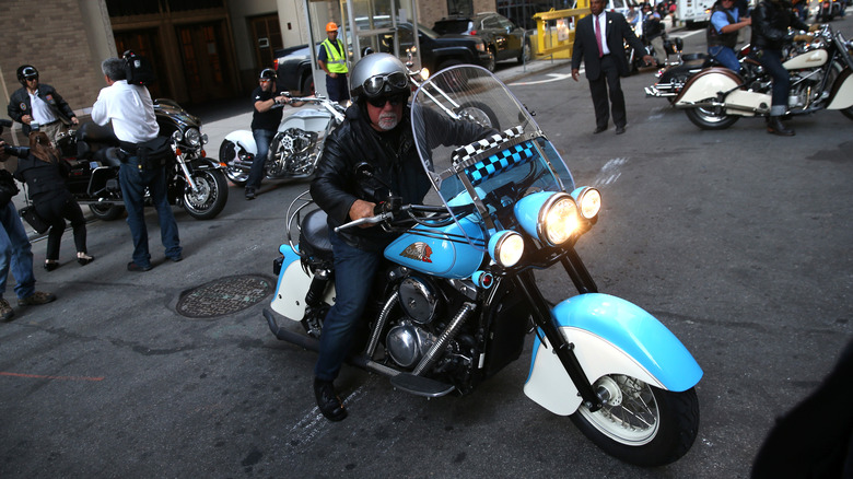 Billy Joel riding one of his classic bikes alongside the New York Fire Department