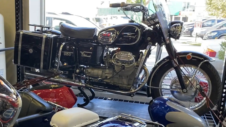 A Moto Guzzi 850 Eldorado mounted on a platform next to a glass window