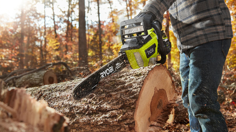 The 40V HP Brushless 16-Inch Chainsaw being used on a fallen tree