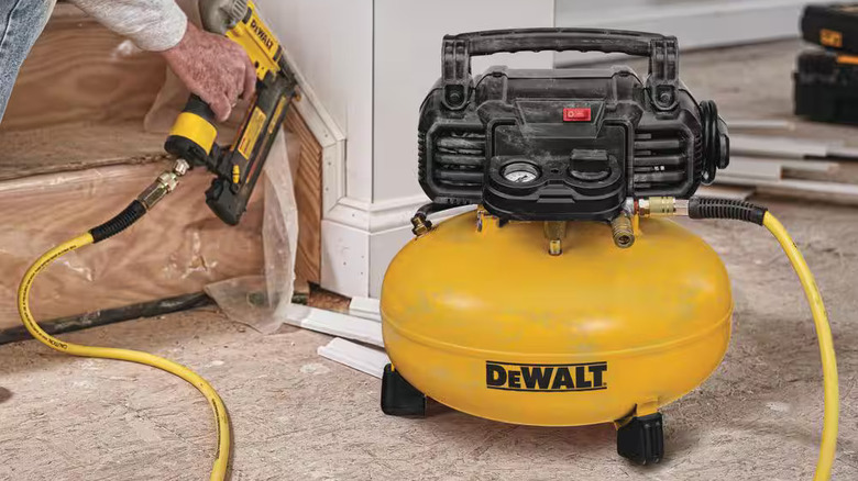 DeWalt air compressor being used to drive nails