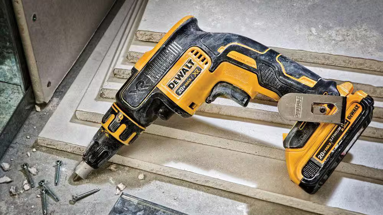 A dirty DeWalt screw gun with screws