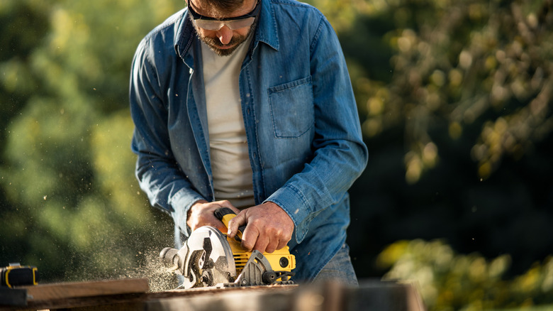 DIYer using a yellow DeWalt circular saw