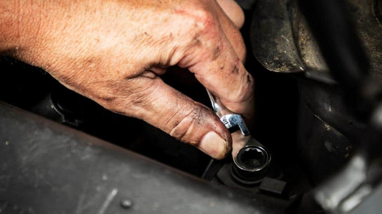 A hand uses the 90-tooth GearWrench ratcheting wrench in a small space.