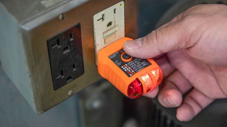 The three-prong Klein outlet tester used on an outlet.