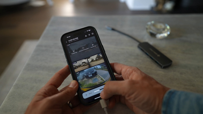 A person using the Perception app to view all four main videos at once from Sentry mode