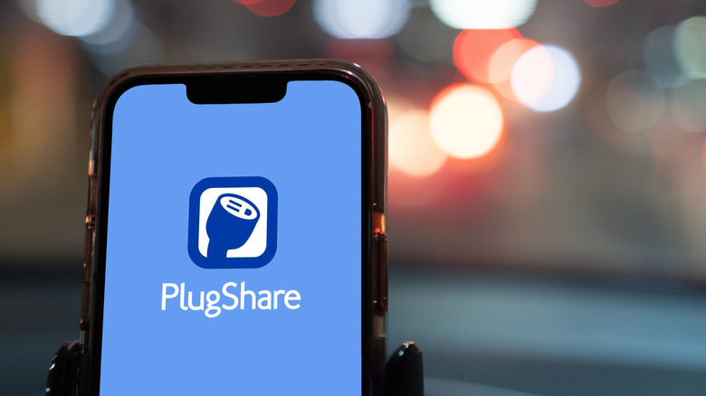 The PlugShare app loading screen on a smartphone that is docked inside a car