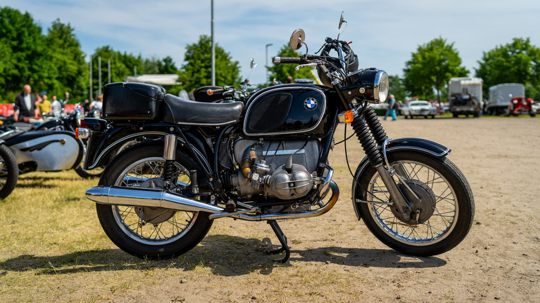 A Black BMW R75/5 standing in a field at an open-air motor show.