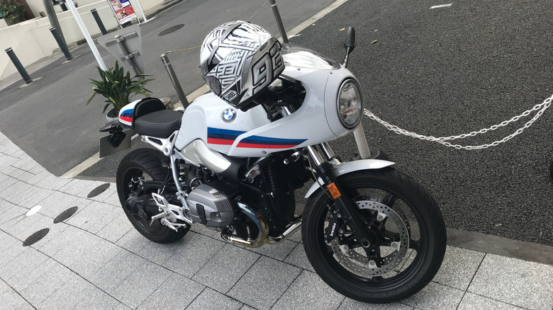 A white BMW R nineT cafe racer parked in Japan outside a store.
