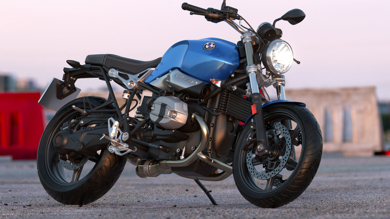 A baby blue BMW R90 parked at the side of a road at dusk.