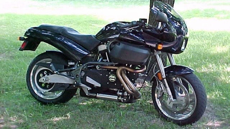 A black Buell S3 Thunderbolt sitting out in the grass, under a tree on a sunny day