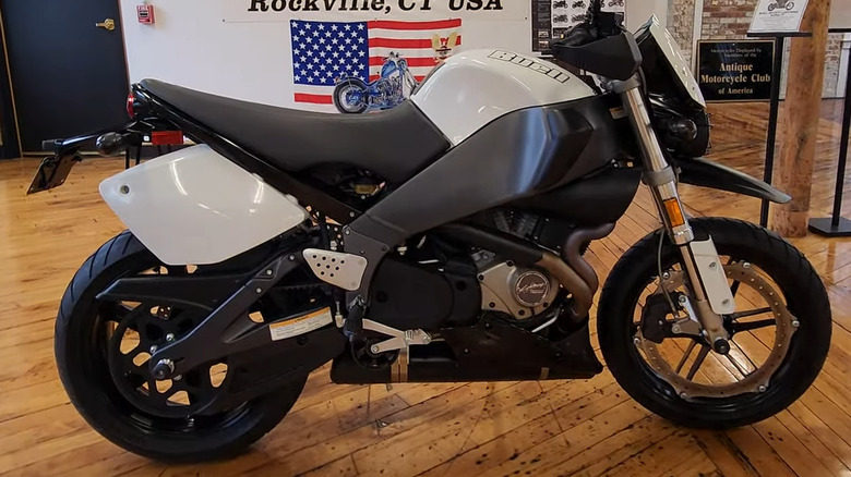 A black and white Buell XB12S Super TT sitting in front of a lawn with palm trees behind it