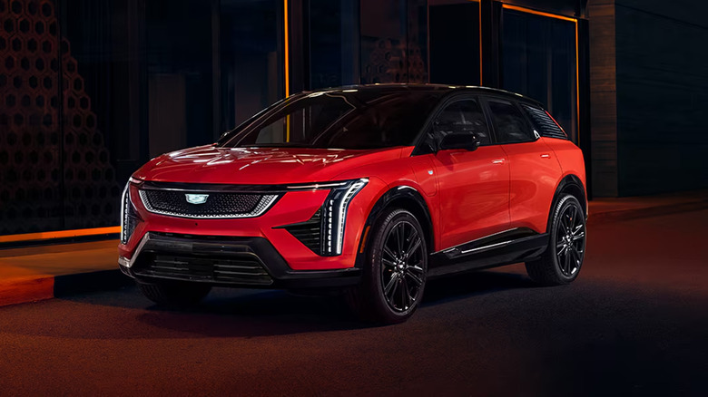 A red Cadillac OPTIC parked on a city street at night