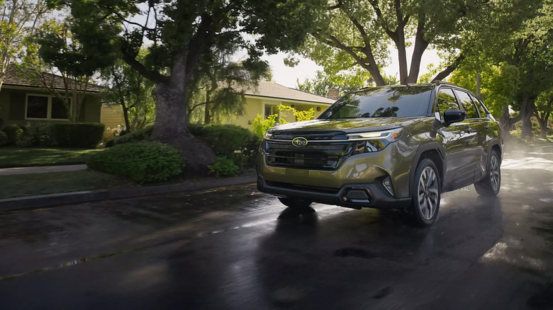 A green Subaru Forester Hybrid driving down a suburban street