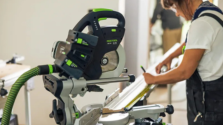 Festool saw with dust extractor attached on stand