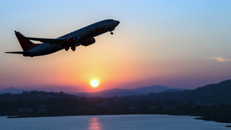 Airplane taking off at sunset.