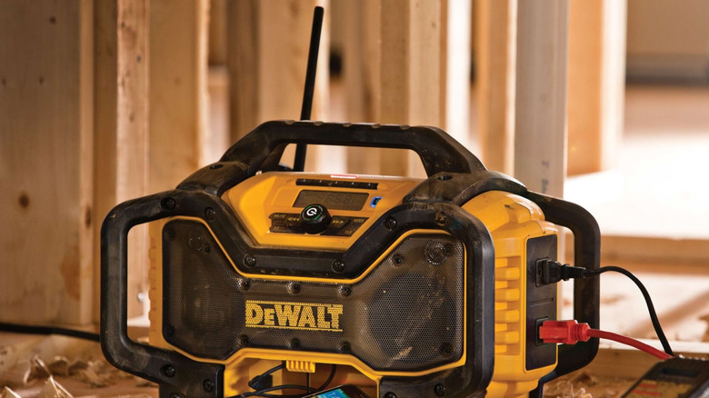 A DeWalt Jobsite Radio Charger with Bluetooth sits on a dusty construction floor.