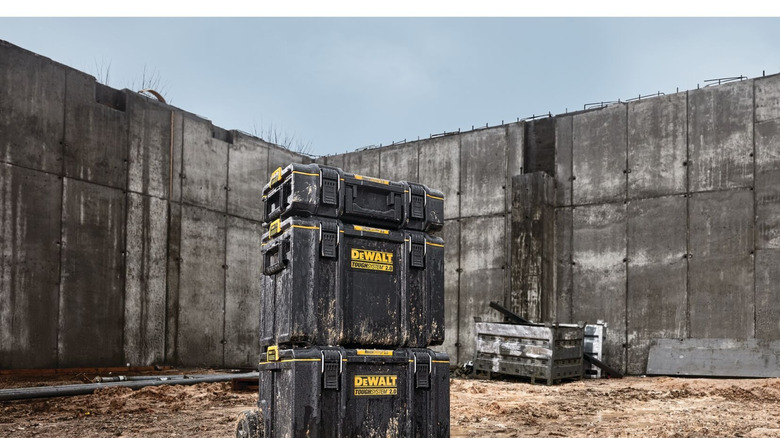 A stacked DeWalt ToughSystem 2.0 Rolling Tower sitting on a muddy construction site.