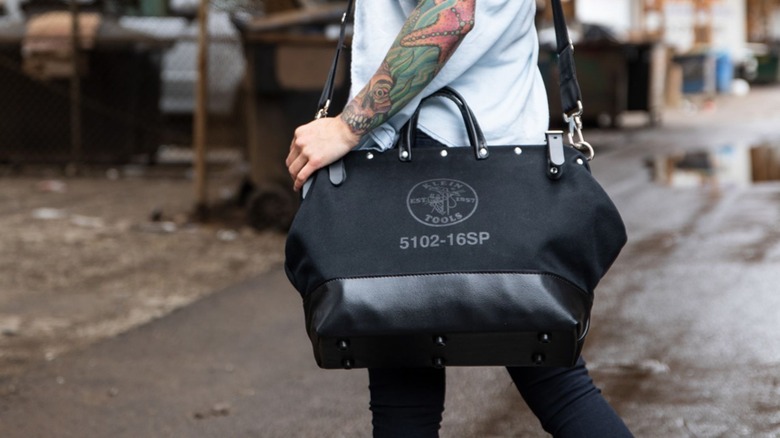 person wearing klein black canvas deluxe tool bag