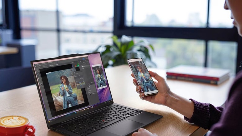 woman using Lenovo ThinkPad X1 Carbon Gen 13 Aura Edition and smartphone