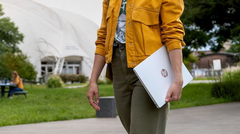 Woman holding HP OmniBook 5 14 while walking