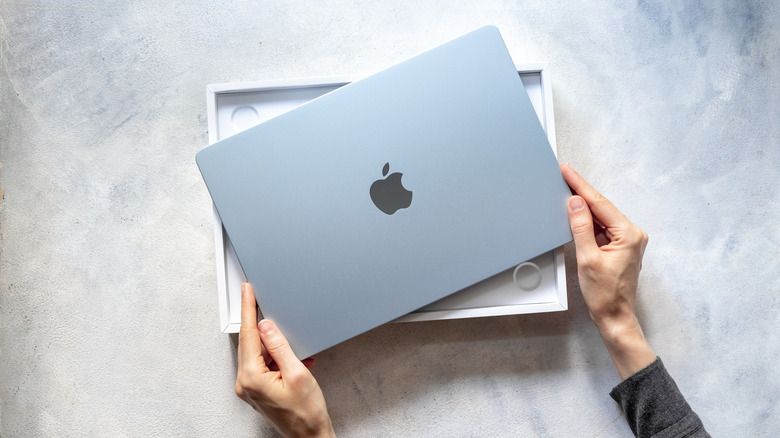 hands unpacking Apple Macbook Air M4 2025 laptop