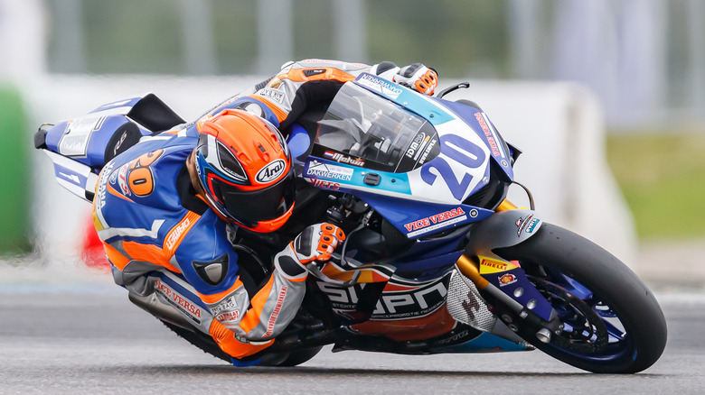 A motorcycle rider turning on a racetrack.